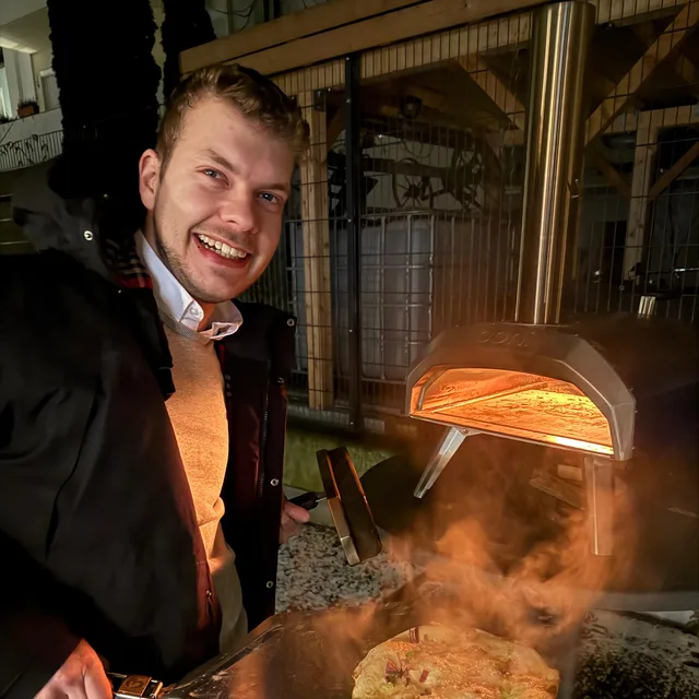 Kollege backt Pizza im Pizzaofen der codegiganten