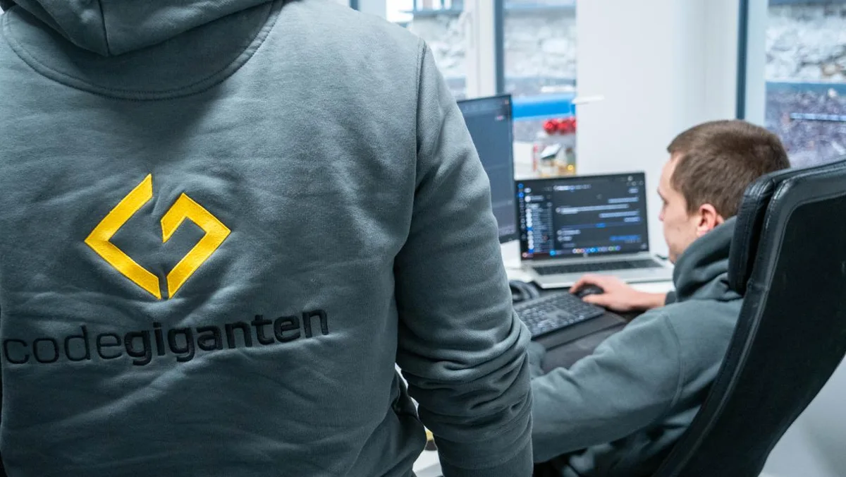 Zwei Entwickler der codegiganten arbeiten im Büro an einem Shopware-Projekt