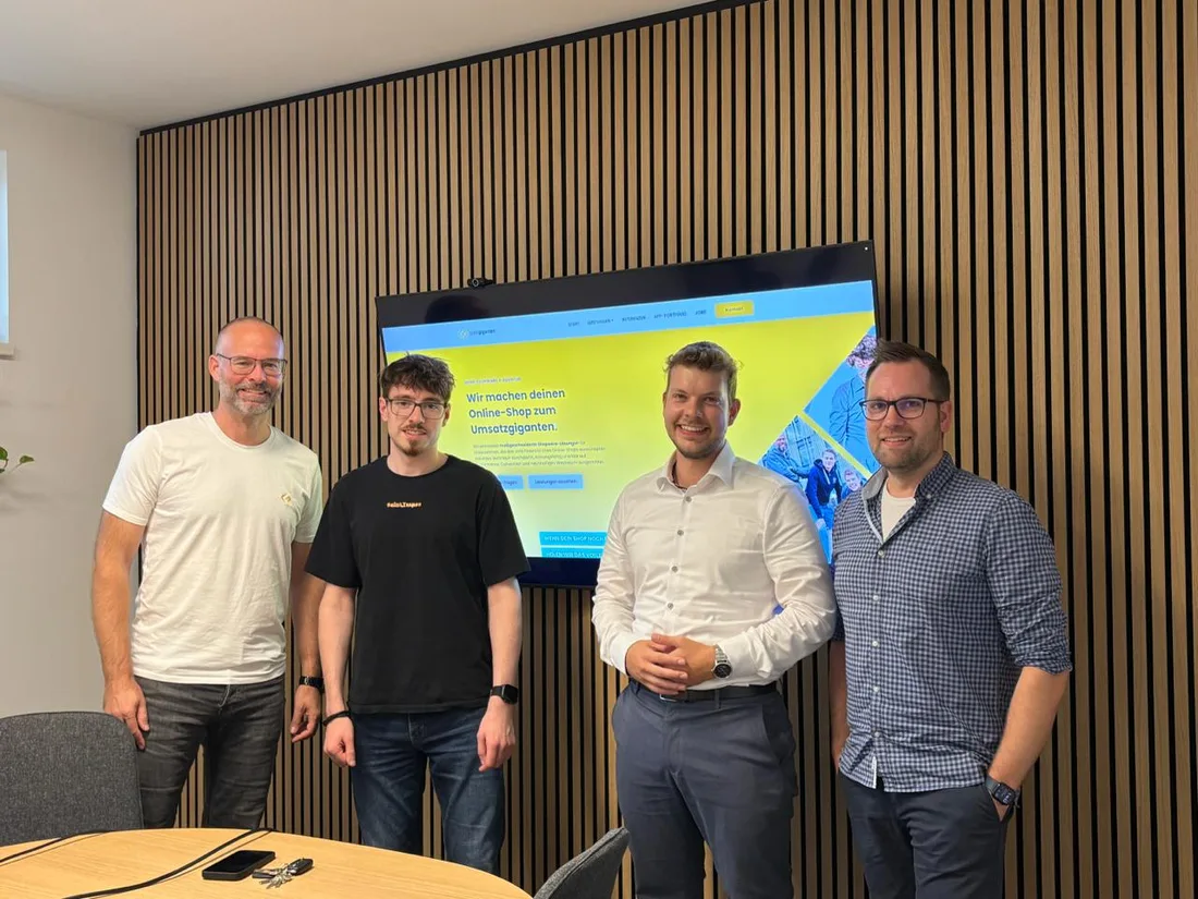 Die Teams von codegiganten und Zenit gemeinsam im Büro vor der codegiganten-Website